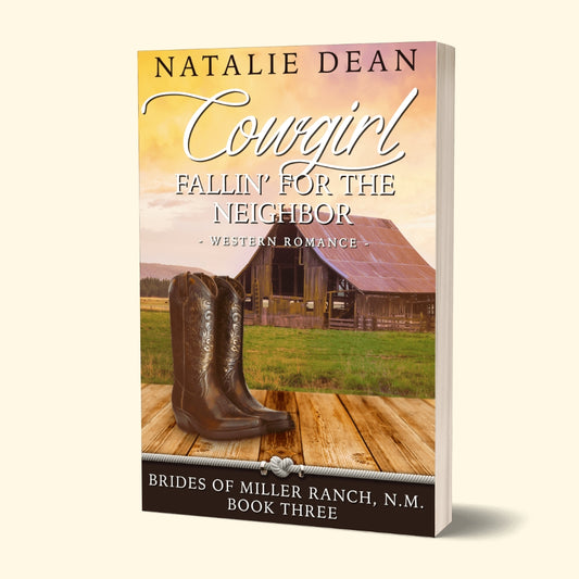 Paperback book mockup of Cowgirl Fallin' for the Neighbor, Brides of Miller Ranch, N.M.  Book Three, western romance by Natalie Dean; pair of womens boots with a barn in the background