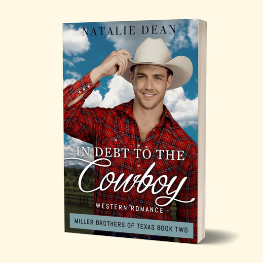 Paperback book mockup of In Debt to the Cowboy, Miller Brothers of Texas Book Two by Natalie Dean, a western romance; cowboy in a flannel shirt with a cloudy sky background